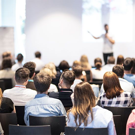 Crowd at a conference watching speaker