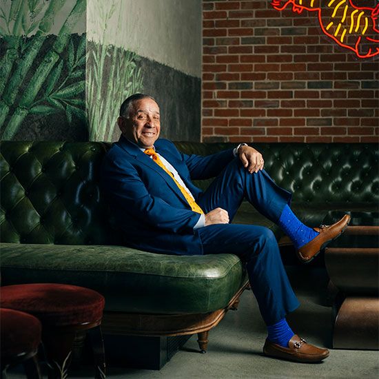 Victor Fuchs in suit on green sofa