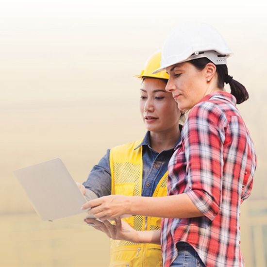 Two female construction workers checking laptop